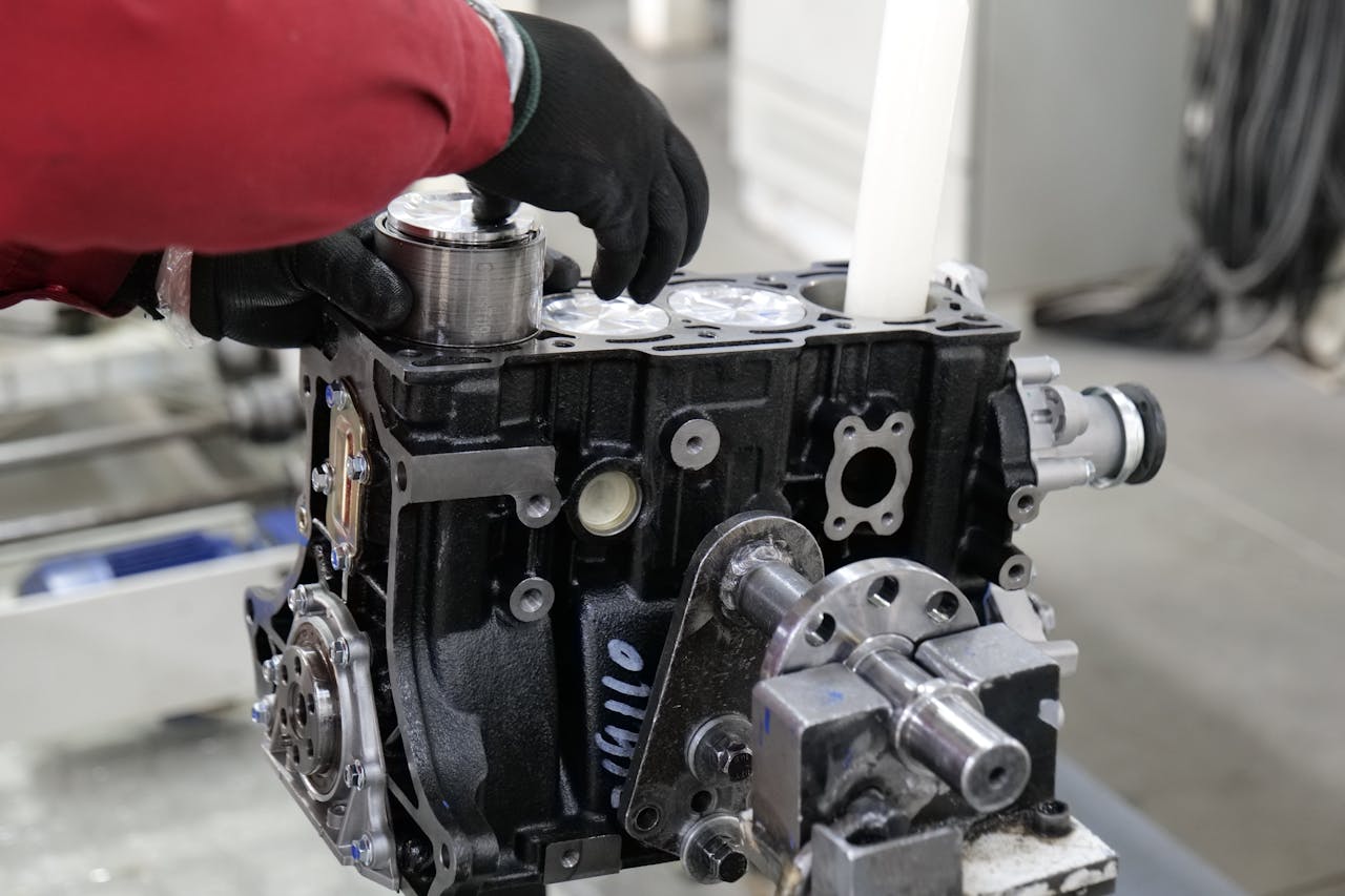 about-04 Mechanic working on engine assembly in a workshop, focusing on precision and craftsmanship.
